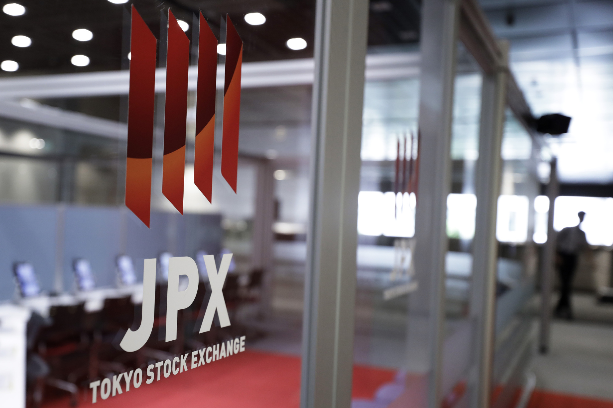 The Japan Exchange Group Inc. logo is displayed on a glass door at the Tokyo Stock Exchange on Aug. 30. Ahead of the Oct. 22 election, foreign investors have been pouring their money into Japanese stocks. | BLOOMBERG