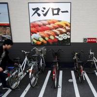 A customer parks a bicycle outside sushi restaurant chain Sushiro in Kawaguchi, Saitama Prefecture in May 2016. | REUTERS