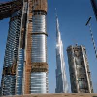 The Burj Khalifa skyscraper (center) stands beyond new skyscrapers under construction in Dubai on Sept. 12. | BLOOMBERG