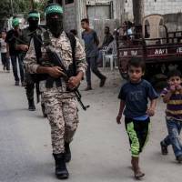 Masked youth cadets from the Ezzedine al-Qassam Brigades, the armed wing of the Palestinian Islamist Hamas movement, march in the southern Gaza Strip city of Khan Yunis on Friday. | AFP-JIJI