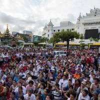 Supporters gather during a rally in support to the Myanmar leader Aung San Suu Kyi on Sunday in front of City Hall in Yangon. Myanmar\'s army said on Sunday it had discovered a mass grave containing the bodies of 28 Hindus, including women and children, in violence-wracked Rakhine state. | AFP-JIJI