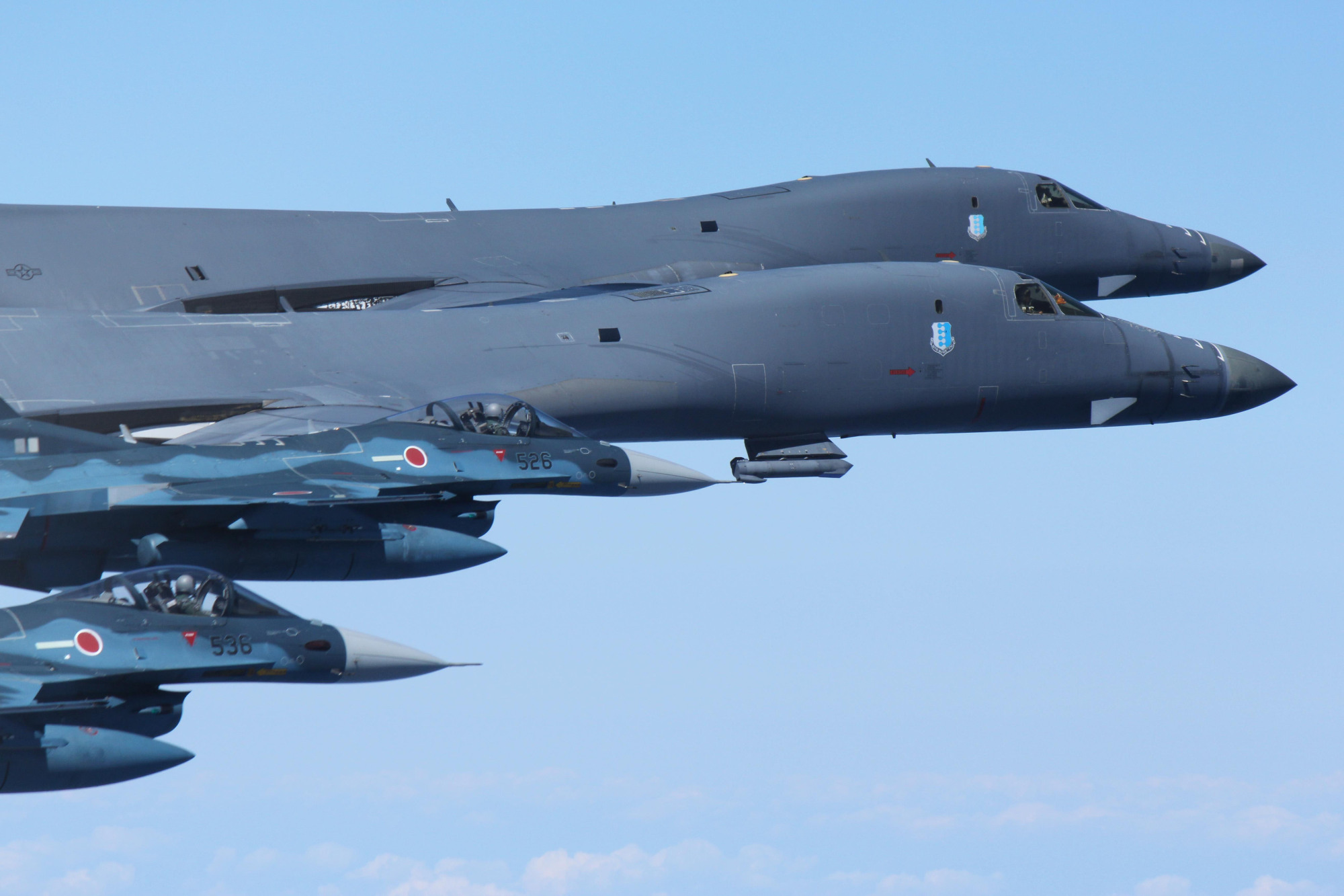 U.S. Air Force B-1B bombers flanking Air Self-Defense Force F-2 fighters execute a bilateral mission over the Pacific Ocean on Monday, in response to North Korean missile tests. | AIR SELF-DEFENSE FORCE