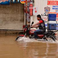 Residents wade through a street flooded by the intense rains of Hurricane Max in Acapulco, Guerrero state, Mexico, Thursday. Mexico braced Thursday for Hurricane Max, which swirled off its southwestern coast, triggering warnings of life-threatening conditions in areas hit by a devastating earthquake last week. | AFP-JIJI
