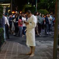 People gather on a street in downtown Mexico City during an earthquake on Thursday. The powerful 8.0 magnitude earthquake struck southern Mexico, the U.S. Geological Survey said, with seismologists warning of tsunami of more than three meters (10 feet). | AFP-JIJI