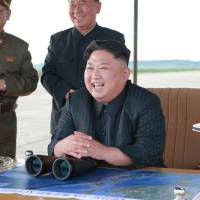 North Korean leader Kim Jong Un watches the launch of a Hwasong-12 intermediate-range ballistic missile in this photo released Saturday. | REUTERS