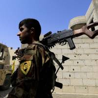 A member of the Syrian Democratic Forces (SDF), a U.S. backed Kurdish-Arab alliance, holds a position in Raqqa on Monday as they battle to retake the northern Syrian city from the Islamic State (IS) group. | AFP-JIJI