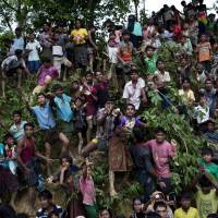 Rohingya stretch their arms out for food being distributed near the Balukhali refugee camp in Cox\'s Bazar, Bangladesh, on Wednesday. | AP
