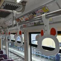 The cat design commemorating the 110th anniversary of the Tamagawa Line is seen on hand straps inside a new tram. | SATOKO KAWASAKI