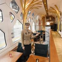 An attendant shows the lounge car of the Train Suite Shiki-shima, operated by JR East, at Ueno Station in Tokyo in March. | CHUNICHI SHIMBUN