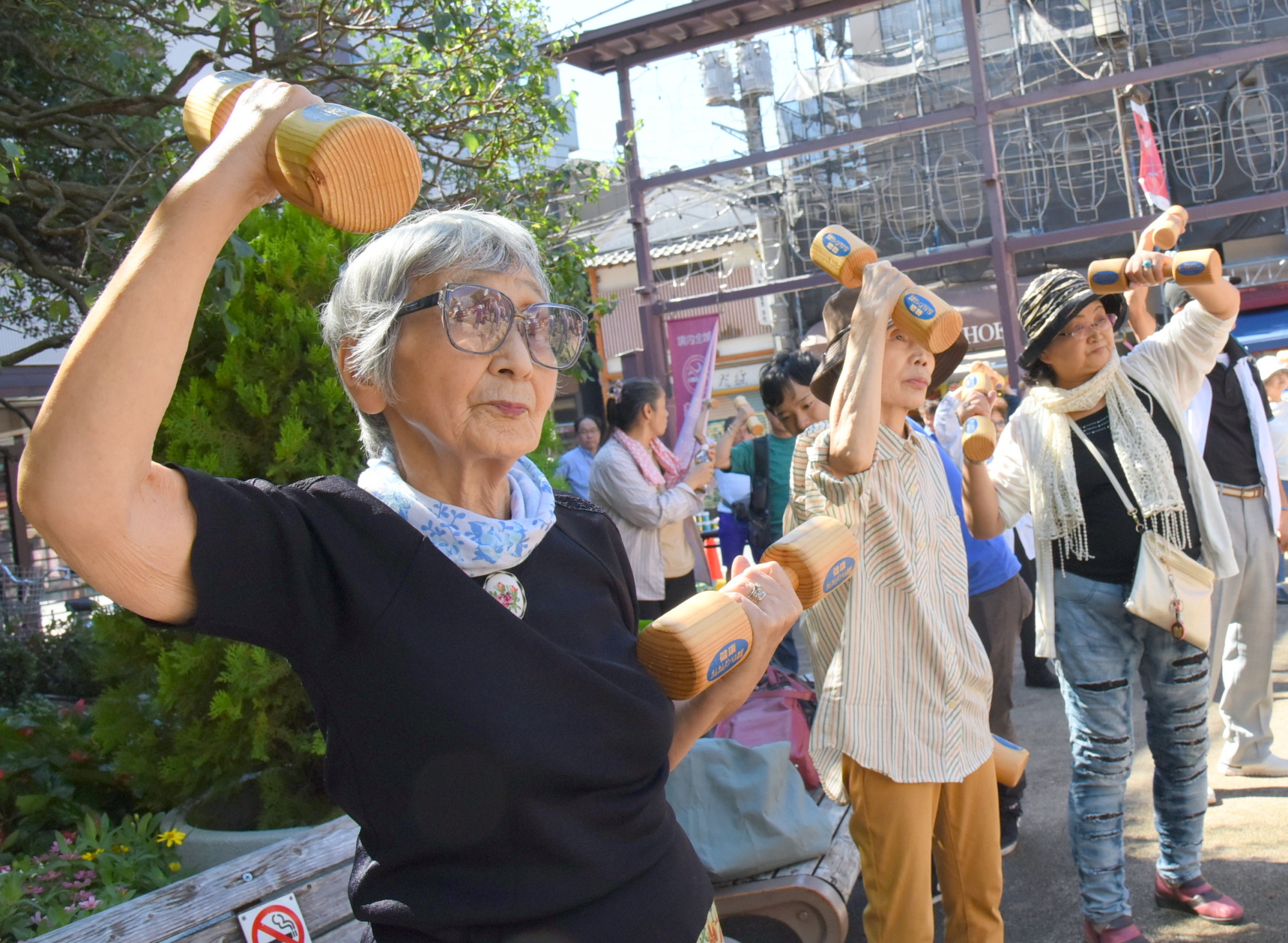 Seniors exercise Monday during a health promotion event for Respect for the Aged Day at Koganji Temple in Tokyo's Sugamo neighborhood. The street near the temple is known as a popular shopping area for seniors. | SATOKO KAWASAKI