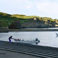 Fishermen return to a port in Okushiri Island, Hokkaido, on the morning of July 29 after a North Korean missile test the previous day. | KYODO