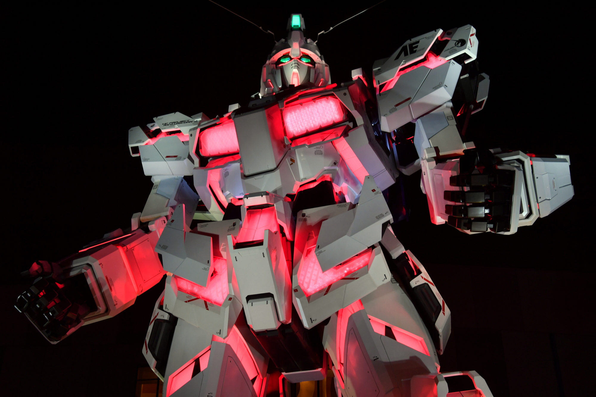 An illuminated life-size Unicorn Gundam statue in 'destroy mode' is shown to the media Saturday night in Tokyo's Odaiba waterfront district. | YOSHIAKI MIURA