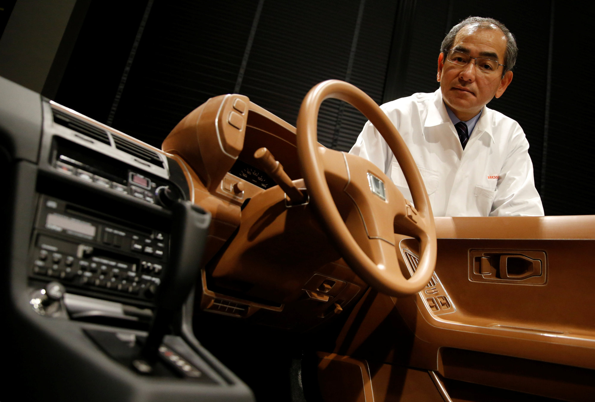Yoshiyuki Matsumoto, senior managing director of Honda Motor Co. and president of Honda R&amp;D Co., shows a model of a Prelude's interior at its R&amp;D center in Wako, Saitama Prefecture, last Dec. 27. | REUTERS