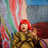Avant-garde artist Yayoi Kusama, 88, speaks to the media at her studio in Tokyo on Tuesday. Kusama, whose exhibitions have been among the hottest tickets in the art world, is now opening a museum in downtown Tokyo dedicated to her paintings and sculptures. | REUTERS