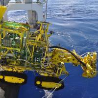 A mining machine is put into water off the coast of Okinawa Tuesday to extract minerals from a deep-water seabed. | AGENCY FOR NATURAL RESOURCES AND ENERGY / VIA KYODO