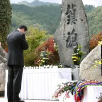 Families of the victims of the eruption at Mount Ontake Wednesday pray before a monument set up in the village of Otaki, Nagano Prefecture. | KYODO