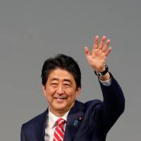 Prime Minister Shinzo Abe waves toward delegates during an India-Japan summit in Gandhinagar, India, on Thursday. | REUTERS