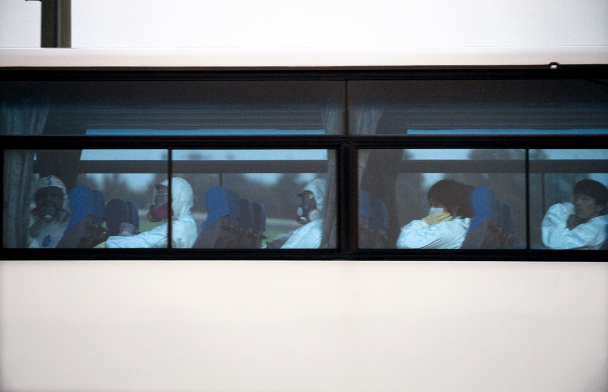 Workers from Tokyo Electric Power Co. travel by bus toward the power plant in April 2011. | ROB GILHOOLY