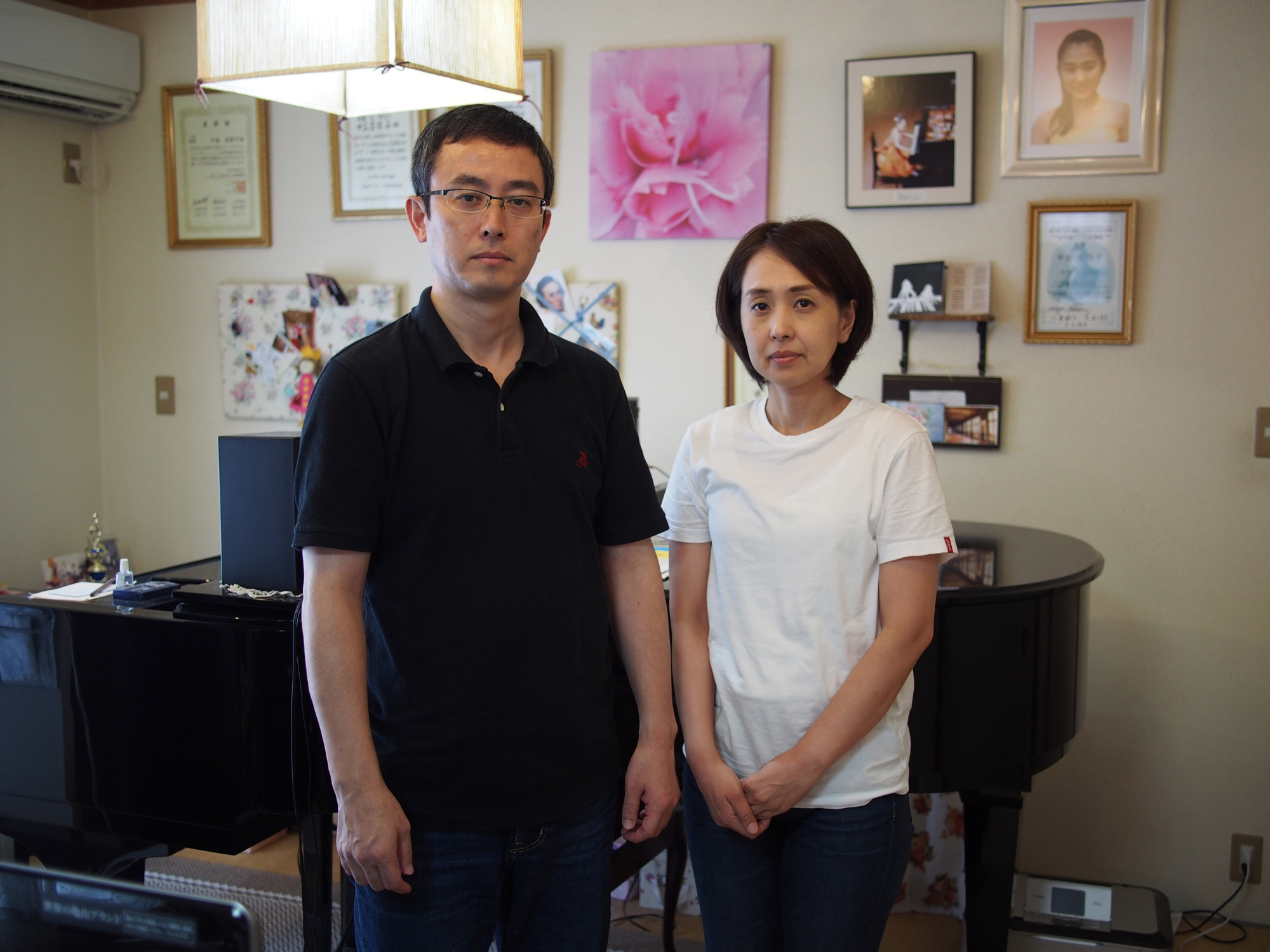 Junko and Takanobu Nakashima stand in front of Naoko's grand piano in August. | MASAMI ITO