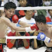 Shun Kubo (left) takes on Daniel Roman of the United States during their WBA super bantamweight title fight in Kyoto on Sunday. | KYODO