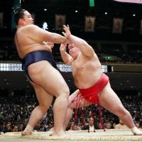 Onosho (right) forces Asanoyama out of the raised ring on Saturday, the 14th day of the Autumn Grand Sumo Tournament, at Ryogoku Kokugikan. | KYODO