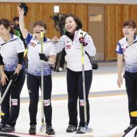 LS Kitami players celebrate a victory over Chubu Electric Power on Saturday in a women\'s curling playoff for the Pyeongchang Winter Olympics in Kitami, Hokkaido. | KYODO
