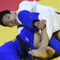 Takanori Nagase (top) and Aziz Kalkamanuli of Kazakhstan compete in the men\'s 81-kg division at the World Judo Championships in Budapest on Thursday. | AP