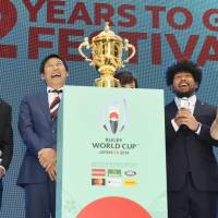 Participants at an event to mark two years to go until the 2019 Rugby World Cup, including Sports Agency commissioner Daichi Suzuki (second left) and Japan national team player Shota Horie (second right) share a joke in Tokyo on Wednesday. | KYODO