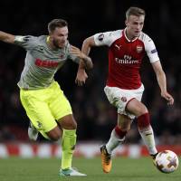 Arsenal\'s Rob Holding (right) moves the ball against Cologne\'s Marco Hoger in Europa League action on Thursday night. Arsenal won 3-1. | AFP-JIJI