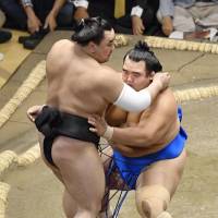 Maegashira Kotoshogiku (right) forces yokozuna Harumafuji out of the raised ring on Tuesday at Ryogoku Kokugikan. | KYODO