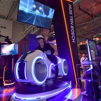 A visitor tries out a virtual reality motorcycle attraction reminiscent of \"Tron\" at a preview of the Tokyo Game Show on Thursday ahead of its official opening to the public this weekend. The attraction is the creation of Tokyo-based firm JPPVR technology. | YOSHIAKI MIURA