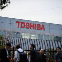 Members of the media stand in line outside a Toshiba Memory Corp. plant ahead of a tour in Yokkaichi, Mie Prefecture, on Oct. 13. | BLOOMBERG