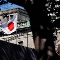 The Japanese flag flutters atop the Bank of Japan. | REUTERS