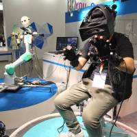 The Telesar V robot copies the movement of a person through wearable control devices Tuesday in the KDDI Corp. booth at the Combined Exhibition of Advanced Technologies (CEATEC) at Makuhari Messe in the city of Chiba. | SHUSUKE MURAI