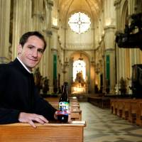 Belgian priest Jeremie poses with a new beer called Ste Kat\' inside Sainte-Catherine church, as he launches the new beer to raise funds for renovation works on the building in Brussels Thursday. | REUTERS