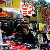 A woman shops for clothing at a shop in Tokyo in January. | REUTERS