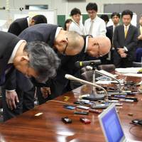 Shoko Chukin Bank executives bow in apology during a news conference Wednesday in Tokyo over shady loans. | KYODO