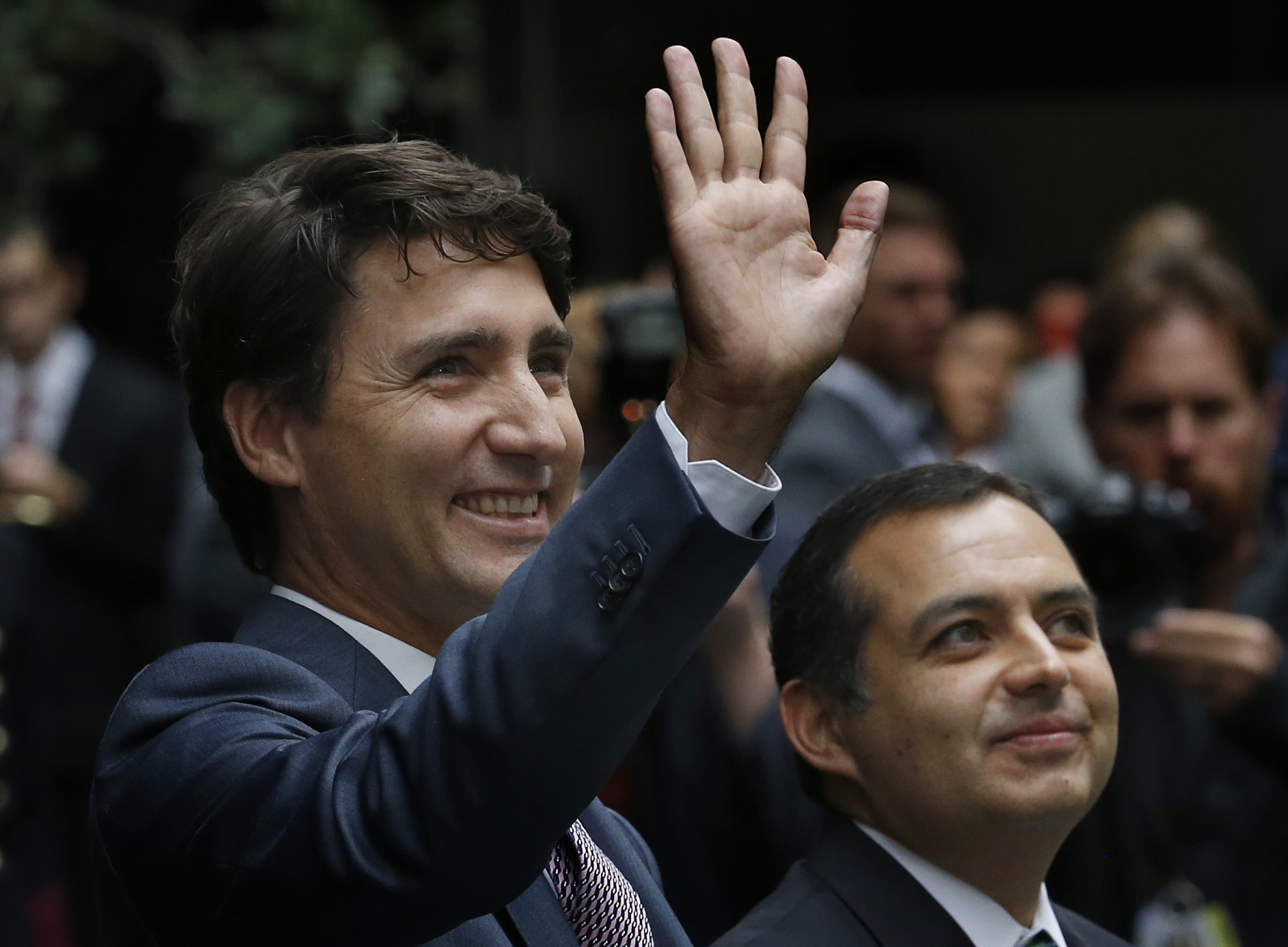 Accompanied by Mexican Senate President Ernesto Cordero (right), Canadian Prime Minister Justin Trudeau waves upon his arrival to the Mexican Senate in Mexico City Friday. Trudeau said in a speech to the senate Friday that support for NAFTA 'depends on the fruits of this trade being fairly shared.' | AP