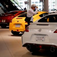 A man looks around a Nissan showroom at the carmaker\'s headquarters in Yokohama. | REUTERS