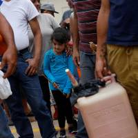 Residents affected by Hurricane Maria wait in line for fuel donated by the Fuel Relief Fund, in the municipality of Orocovis, outside San Juan, Puerto Rico, on Tuesday. | REUTERS