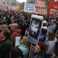 A protester holds a photo of Santiago Maldonado during a demonstration at Plaza de Mayo in Buenos Aires Sunday. Human rights groups say Maldonado went missing two months ago after Argentine border police captured him during an operation against Mapuche Indians who were blocking a highway in Argentina\'s Patagonia. | AP