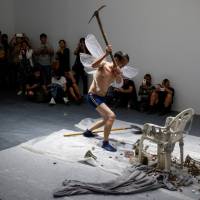 Huang Wenya, a Chinese performance artist, smashes objects as he performs \"Aftersound\" at the OPEN international performance art festival in the Songzhuang art colony near Beijing in September. | REUTERS