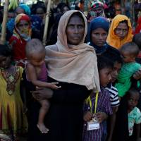 Rohingya refugees wait for food aid on Saturday at the Balukhali camp near Cox\'s Bazar, Bangladesh. | REUTERS