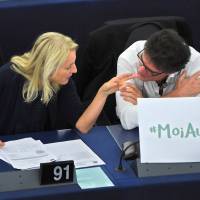 An Austrian member of the European Parliament, Evelyn Regner (left), and French MEP Patrick Durand talk Wednesday during a debate about sexual harassment in Strasbourg, France. The placard refers to the hashtag #MoiAussi (#MeToo). | AFP-JIJI