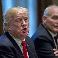 U.S. President Donald Trump speaks as John Kelly, White House chief of staff, listens during a briefing with senior military leaders in the Cabinet Room of the White House in Washington on Thursday. | BLOOMBERG
