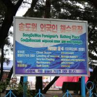 A sign in English, Russian and Korean marks the foreigners-only section of Songdowon Beach in Wonsan, North Korea, in August 2010. | RAYMOND CUNNINGHAM / VIA REUTERS