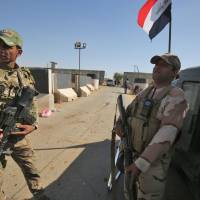 Members of the Iraqi government\'s Emergency Response Brigade (ERB) stand guard at the Bai Hassan oil field, west of the multiethnic northern Iraqi city of Kirkuk, on Thursday. | AFP-JIJI