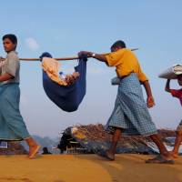 Rohingya refugees carry their sick relative to a medical center at the Kutupalong refugee camp near Cox\'s Bazar, Bangladesh, Tuesday. | REUTERS