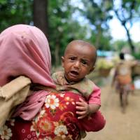 Rohingya refugees, who crossed the border from Myanmar two days earlier, walk after they received permission from the Bangladesh army to continue their way to the Kutupalong refugee camp, in Balukhali near Cox\'s Bazar, Bangladesh, Thursday. | REUTERS