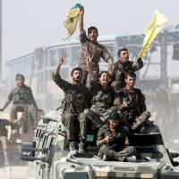 Syrian Democratic Forces fighters celebrate victory in Raqqa on Tuesday. | REUTERS